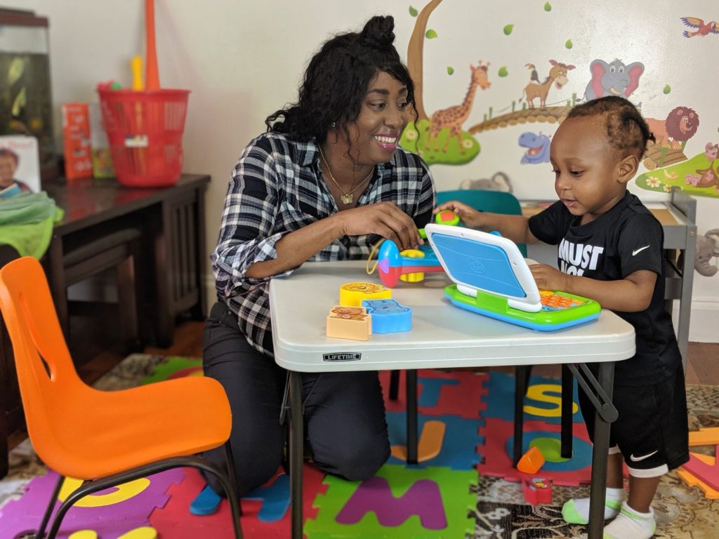 Letoya and her son play with a toy laptop
